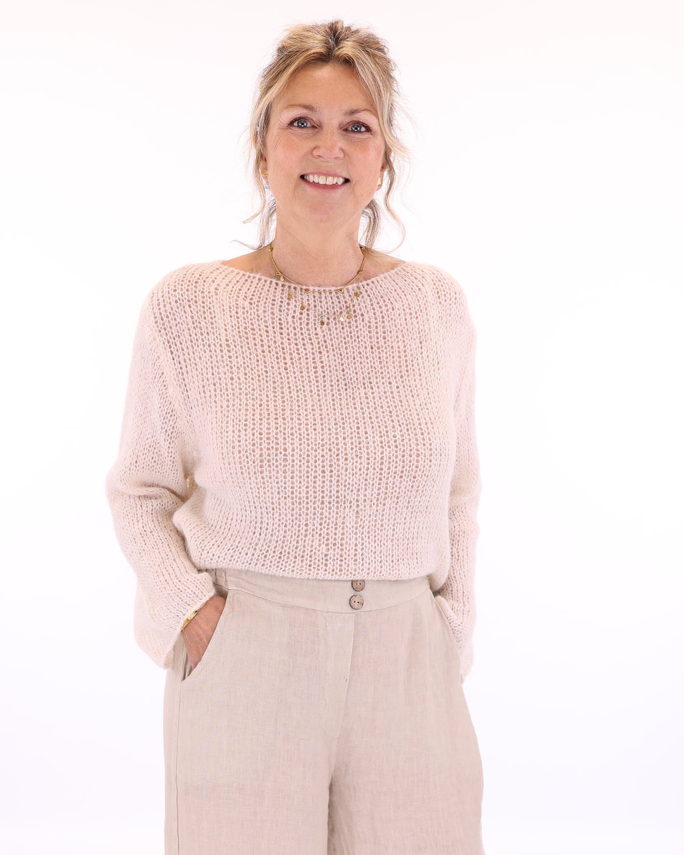 Women's long sleeve cobweb knitted alpaca blend sweater in cream, worn with cream linen  trousers, made in Italy