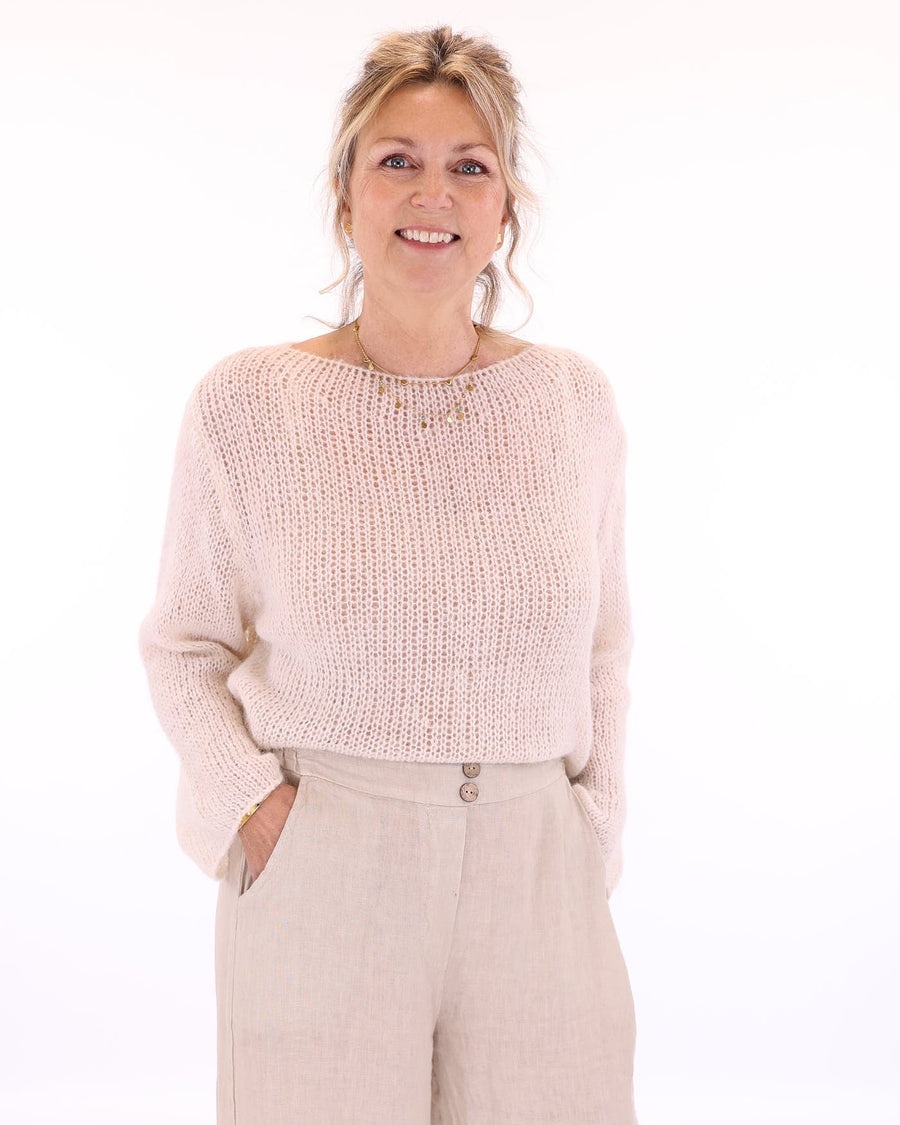 Women's long sleeve cobweb knitted alpaca blend sweater in cream, worn with cream linen  trousers, made in Italy