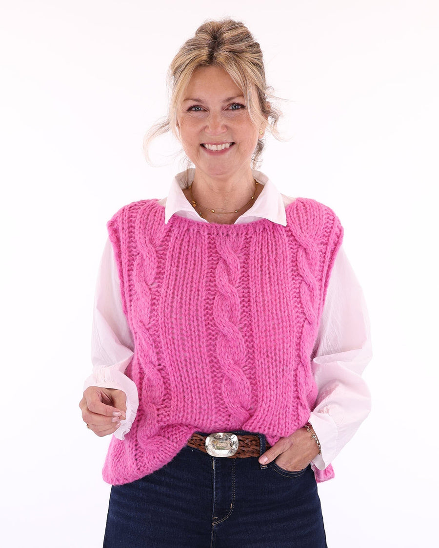 Women's alpaca blend cable knit tank top for Spring/Summer in fuchsia pink, worn over a white long sleeve shirt with a collar, made in Italy