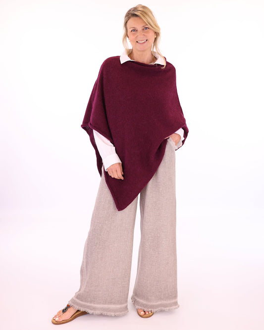Women's Italian Linen Full Length Trousers with pockets and a frayed hem in taupe, worn with an alpaca poncho in dark red