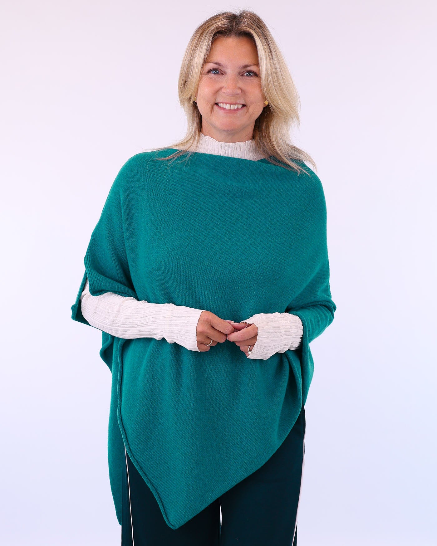 Women's cashmere blend poncho in teal blue, worn with long sleeve cream T-shirt, made in Italy