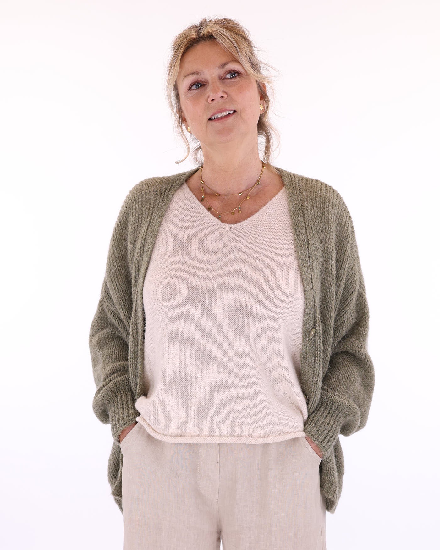 Women's long sleeve V neck alpaca blend knitted cardigan with front patch pockets and three buttons in moss green, worn over alpaca blend V neck tunic, made in Italy